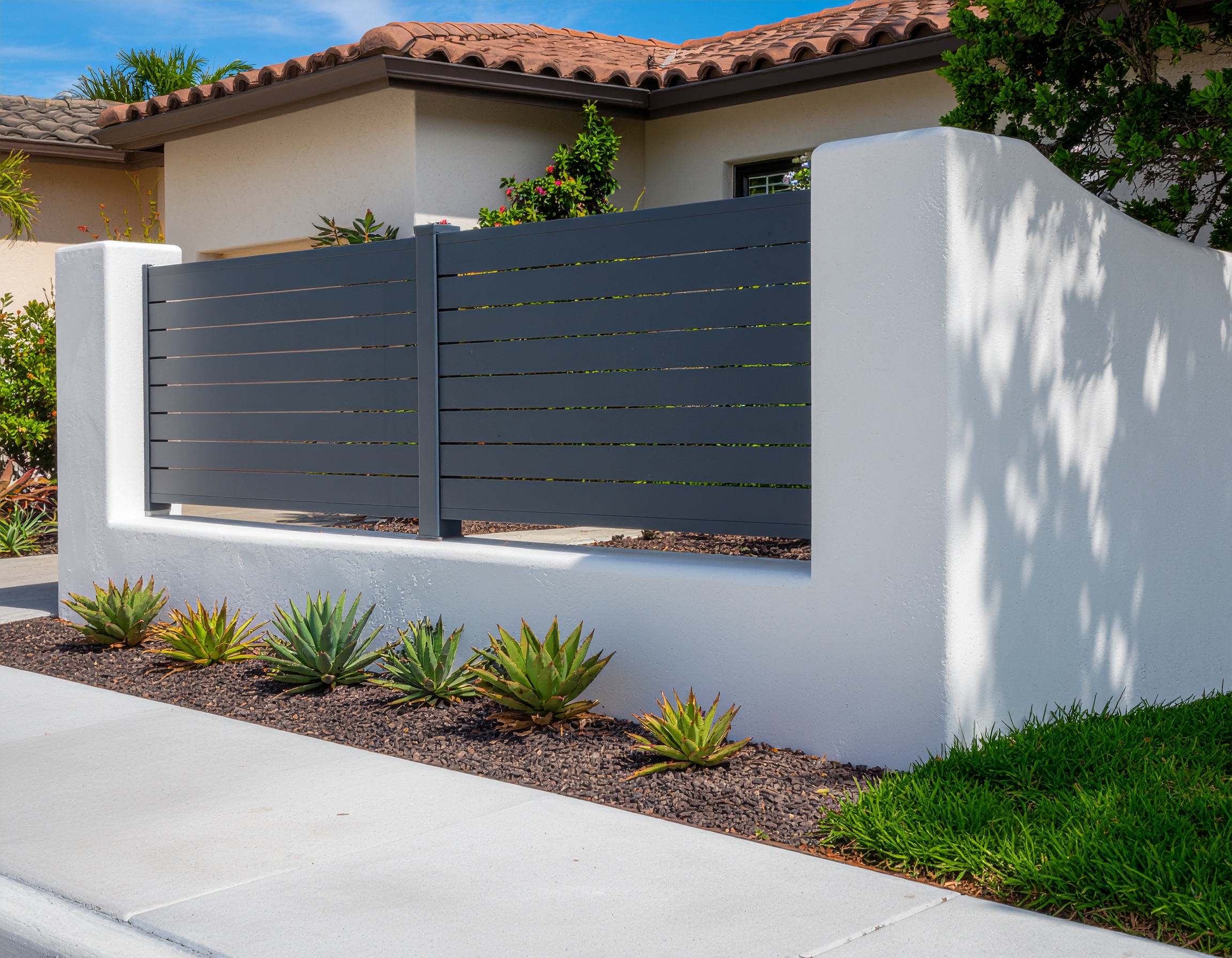 Gray metal slat fence, white wall.-deck builder-San Antonio, Texas