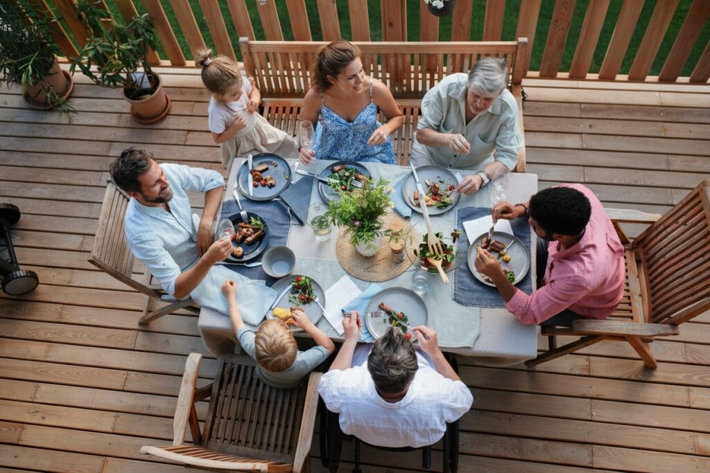 family and friends enjoying a meal on a deck - San Antonio Deck and Fence Works