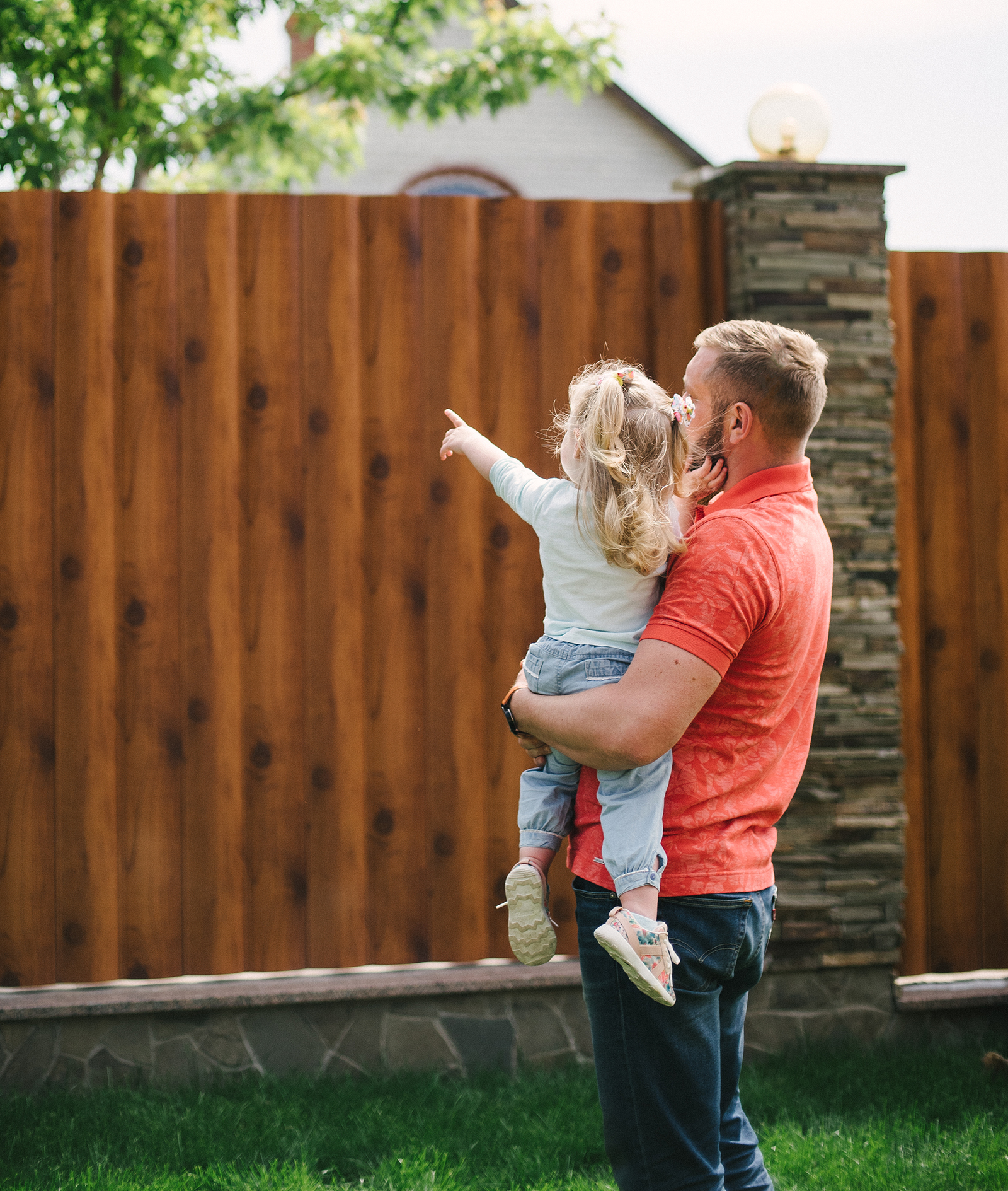 young family girl and guy with small children walking on green g - San Antonio Deck and Fence Works Happy family enjoying a new fence - San Antonio, Texas